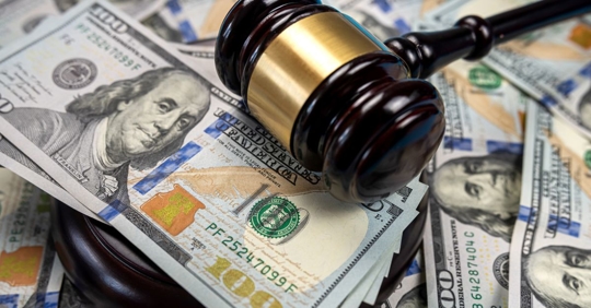 Gavel on top of multiple $100 bills